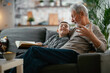 © JustLife - Grandfather and grandson reading a book. Grandpa and grandson enjoying at home.