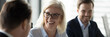 © fizkes - Mature businesswoman lead negotiations, during business meeting with company investor or client businesspeople laughing enjoy friendly talk concept. Horizontal photo banner for website header design