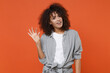 © ViDi Studio - Confused young african american woman girl in casual clothes isolated on orange background studio portrait. People lifestyle concept. Mock up copy space. Gesturing demonstrating size with workspace.
