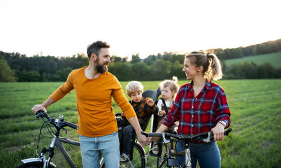 Family with two small children on cycling trip, resting.