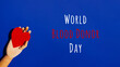 Wooden hand with big red heart in a giving gesture. World Blood Donor Day wording. Donation, help, health issues, antibody plazma concepts. Banner format