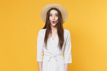 Shocked amazed young brunette woman girl in white dress hat posing isolated on yellow background studio portrait. People sincere emotions lifestyle concept. Mock up copy space. Keeping mouth open.