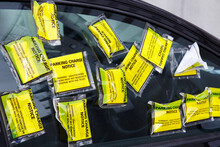 A Car Has Numerous Yellow Parking Tickets On The Side Window. It Is Parked In A Restricted Zone With Residential Parking Only.