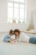 © Elena - A young mother spends time with her little daughter at home.