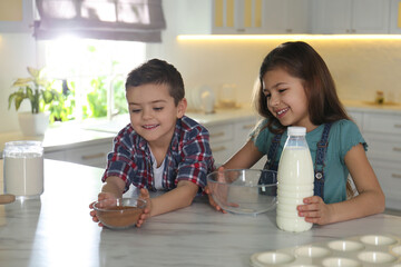 Sticker - Cute little children at table with cooking ingredients in kitchen