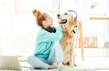 Wall Mural - Girl putting headphones on cute dog