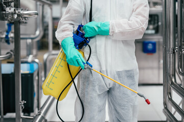 Wall Mural - Exterminator in industrial plant spraying pesticide with sprayer.