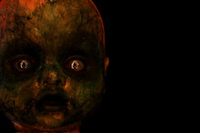 Creepy Evil Looking Doll. Reflected In Its Eyes Is A Trace Of Light Forming A Pentagram.. Copy Space To Right.