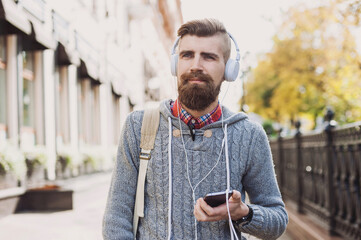 Young man texting on his smartphone in the city. Student men using mobile phone outdoor, travel, lifestyle, technology, communication concept