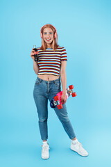 Canvas Print - Image of girl in headphones posing with skateboard and drinking soda