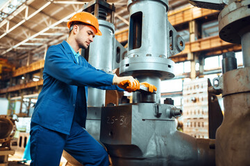 Poster - Engineer in uniform and helmet works on factory