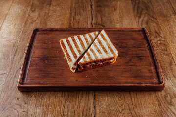 Two halves of a fresh club sandwich on a wooden background