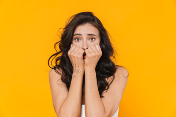 Image of scared young woman covering her face and looking at camera