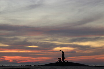 Wall Mural - silhouette of a people on the beach at sunrise