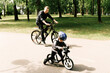 © ksyusha_yanovich - Happy little boy rides a bike with a young dad in the Park