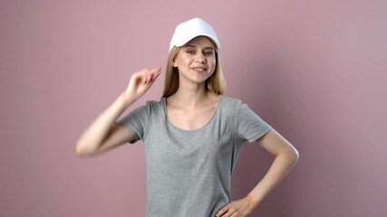 Wall Mural - Young woman trying on stylish cap against color background