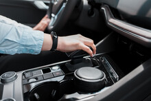 Business woman holds her hand on the gear selector automatic transmission