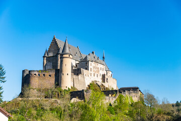 Wall Mural - Vianden castle on the hill view with blue sky background and green trees. Luxembourg