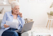 © Prostock-studio - Working On Retirement. Elderly Woman Holding Papers And Using Laptop At Home