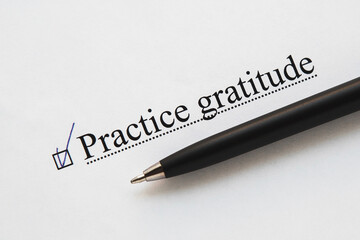 a piece of paper with the inscription practice gratitude from to do list with a tick