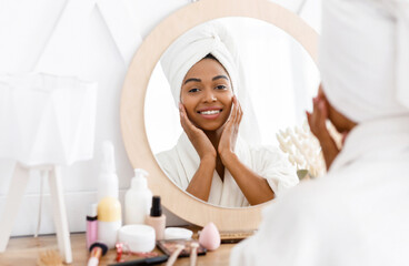 Wall Mural - Beauty skincare. Young beautiful black woman touching her face near mirror