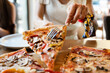 Close up on slice of pizza unknown caucasian woman taking food from the plate at the restaurant in summer day front view unhealthy eating