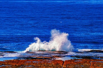 Waves of the blue sea splashing  on the rocky shore