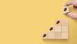 © Monster Ztudio - Hand arranging wood block stacking as step stair on paper yellow background with copy space. Ladder career path concept for business growth success process