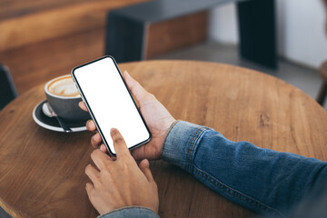 cell phone mockup image blank white screen.woman hand holding texting using mobile on desk at coffee shop.background empty space for advertise.work people contact marketing business,technology