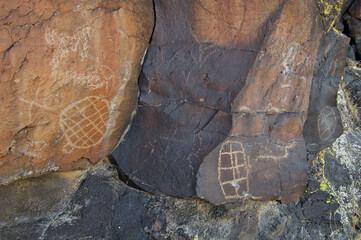 Different degrees of patination on rock surface and petroglyphs, Mojave National Preserve, California. Unfortunate graffiti too