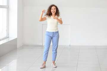 Canvas Print - Happy young woman with key in her new flat