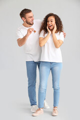 Canvas Print - Happy young couple with key on grey background