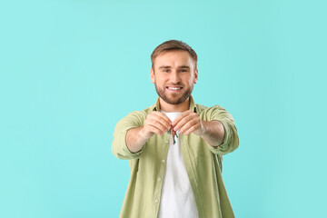 Canvas Print - Happy young man with key on color background