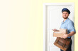 © Pixel-Shot - Handsome young postman near door