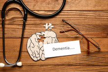 Word DEMENTIA With Human Brain, Eyeglasses And Stethoscope On Wooden Background