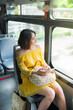© makistock - Young beautiful woman holding mobile phone and looking outside when sitting on bus