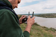 © arthurhidden - Young man piloting drone outdoor in nature. Guy testing aerial unmanned vehicle at nature. Backdrop for adult entertainment