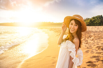  happy young woman walking  on the beach at sunset