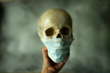 COVID-19 Skull Wearing Face Medical Mask. Coronavirus Death Concept.