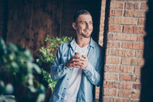 Photo Of Handsome Homey Guy Leaning Brick Design Wall Look Window Drink Hot Fresh Coffee Dreamy Imagination Flight Want Go Out Stay Home Quarantine Time Weekend Living Room Indoors