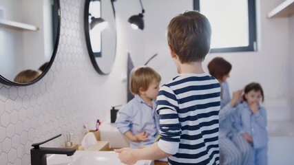 Wall Mural - Mother with small children in pajamas in bathroom at home, brushing teeth.