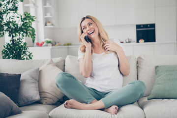 Canvas Print - Photo of domestic cheerful beautiful blond lady sit couch hold telephone chatting talking friends family relatives quarantine stay home good mood legs crossed living room indoors