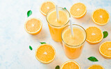 Fototapeta Kuchnia - orange juice in a glass, top view, slices of oranges, straw, healthy lifestyle concept