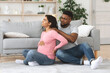 © Prostock-studio - Pregnant black woman suffering from backache, husband massaging her shoulders