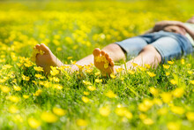 Child Relaxing In A Meadow Full Of Buttercups In The Summer Sun