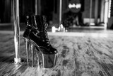 Pole dance shoes with high heels and high platform, black leather with red platform. closeup