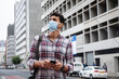 © Wavebreak Media - Caucasian man wearing a covid19 coronavirus mask outside and using his phone