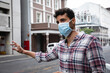 © Wavebreak Media - Caucasian man wearing a covid19 coronavirus mask and looking for a taxi