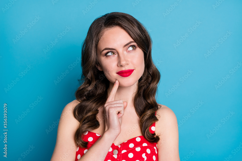 Closeup photo of attractive curly lady minded good mood arms crossed look up empty space interested creative arm on chin wear red dotted dress singlet isolated blue color background - obrazy, fototapety, plakaty 