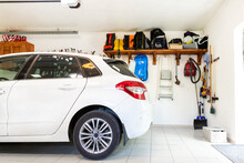 Home Suburban Car Garage Interior With Wooden Shelf , Tools And Equipment Stuff Storage Warehouse On White Wall Indoors. Vehicle Parked At House Parking Background